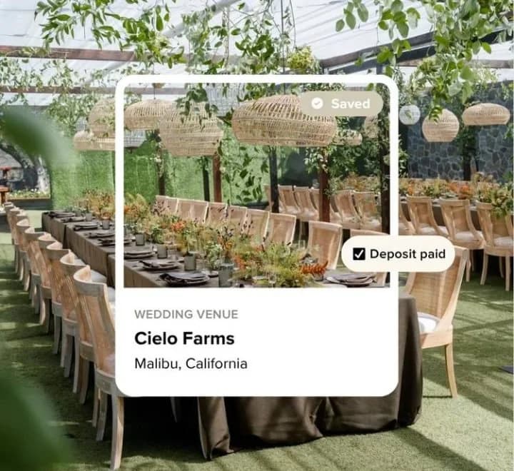 A venue card from Loverly's vendor manager over a garden reception